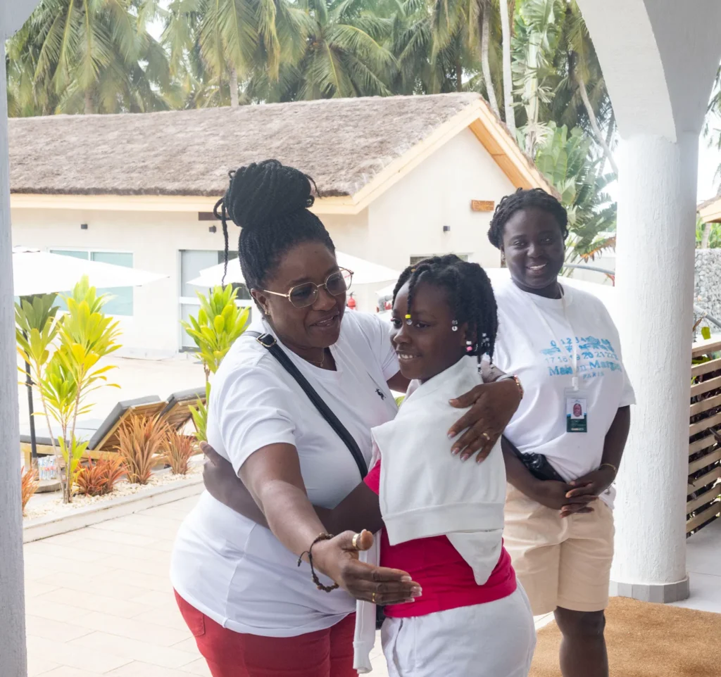 Une encadrante accueille une enfant, au camp Mi-Adja 2025 à San Pedro